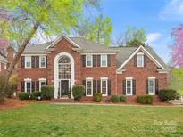 Charming two-story brick home with a manicured lawn, mature trees, black shutters, and a welcoming front entrance at 9743 Aegean Ct, Huntersville, NC 28078
