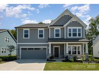 Charming two-story home with gray siding, stone accents, and a well-manicured lawn at 1308 Stone Marker Dr, Monroe, NC 28112