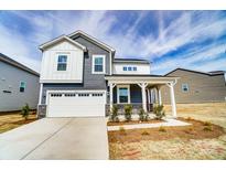 Charming two-story home featuring a two-car garage and covered front porch at 1471 Honey Trl, Monroe, NC 28112