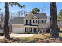 Charming two-story home with an attached garage, well-maintained lawn and black window shutters at 152 Painted Bunting Dr, Troutman, NC 28166