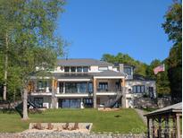 Stunning three-story lake house with a beach, outdoor staircases, and lush landscaping at 180 Willow Point Rd, Troutman, NC 28166