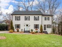 Charming two-story home featuring a lush lawn, crisp white exterior, and classic black shutters at 199 Ingleside Se Dr, Concord, NC 28025