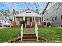 Charming brick home featuring a welcoming front porch with classic columns and landscaped front yard at 2125 Shenandoah Ave, Charlotte, NC 28205