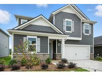 Charming two-story home with gray siding, stone accents, white trim, and an attached two-car garage at 330 Knotty Wood Dr # 67, Monroe, NC 28110