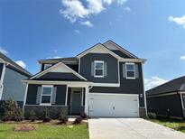 Charming two-story home featuring a two-car garage, stone accents, and a well-manicured front lawn at 330 Knotty Wood Dr # 67, Monroe, NC 28110
