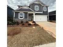 Charming two-story home featuring a manicured lawn, a two-car garage, and stone accents at 330 Knotty Wood Dr # 67, Monroe, NC 28110