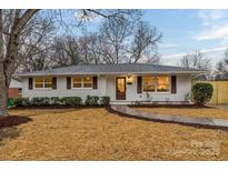 Charming brick home with dark shutters, a light-colored roof, and a beautifully landscaped front yard with a walkway to the front door at 4531 Rockford Ct, Charlotte, NC 28209