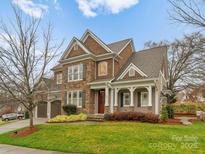 Beautiful two-story home featuring a stone and brown shingle exterior and a well-manicured lawn at 7029 Gardner Pond Ct, Charlotte, NC 28270