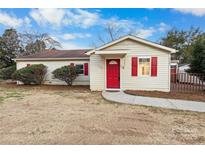 Charming single-story home with a red door and shutters, complemented by a well-maintained front yard at 717 Perth Rd, Troutman, NC 28166