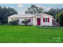 Charming one-story home with a bright red front door, shutters, and a well-manicured lawn at 717 Perth Rd, Troutman, NC 28166