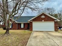 Charming brick home with a two-car garage and manicured lawn at 8309 Emily Dr # 222, Harrisburg, NC 28075