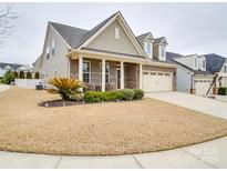 Charming single-Gathering home with manicured lawn, brick accents, and a two-car garage at 105 Blossom Ridge Dr, Mooresville, NC 28117
