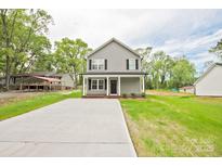 Charming two-story home with a gray exterior and black shutters, complemented by a spacious front yard at 1412 Meadow Ave, Kannapolis, NC 28083