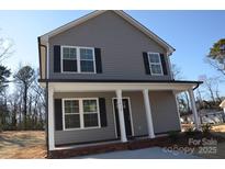 Charming two-story home with gray siding, black shutters, and inviting front porch at 1412 Meadow Ave, Kannapolis, NC 28083