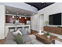 Bright living area flows into a modern kitchen with stainless appliances and bar seating at 2338 Yadkin Ave # 205, Charlotte, NC 28205