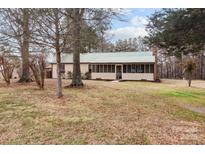 Charming single-story home featuring a screened porch, metal roof, and mature trees on a spacious lot at 2845 Wood Gate Rd, Lincolnton, NC 28092
