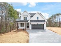 Charming new construction home with a dark garage door and inviting covered porch at 3646 46Th Ne Ave, Hickory, NC 28601