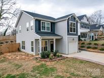 Charming two-story home featuring gray siding, dark shutters, and a well-manicured front yard at 711 E 3Rd Ave, Gastonia, NC 28054