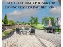 An outdoor patio boasts a fire pit, dining set, and trampoline, perfect for relaxing or entertaining in the backyard at 137 Tenth Green Ct, Statesville, NC 28677