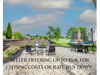 Outdoor patio with a fire pit, seating, dining area, trampoline, and manicured landscaping offers relaxation and entertainment at 137 Tenth Green Ct, Statesville, NC 28677