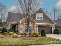 Charming single-Gathering home featuring a stone facade, manicured landscaping, and a two-car garage at 2006 Wesley Landing Rd, Waxhaw, NC 28173