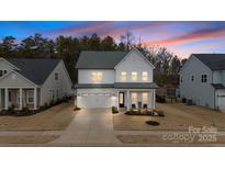 Stunning two-story home with a two-car garage, covered porch, and manicured lawn at 4159 Millstream Rd, Denver, NC 28037