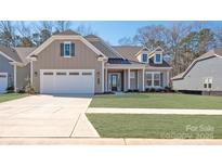 Beautifully landscaped two-story home with attached two car garage and well manicured lawn at 6055 Brush Crk, Monroe, NC 28110