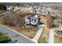 An aerial view showcases the two-story home with an extended driveway and a beautifully landscaped front yard at 662 Georgie St, Troutman, NC 28166