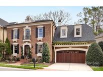 Charming brick home with a well-manicured lawn, garage, and inviting curb appeal at 6711 Conservatory Ln, Charlotte, NC 28210