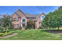 Elegant brick home with lush landscaping and a well-manicured lawn creates a welcoming curb appeal at 9316 Whispering Wind Dr, Charlotte, NC 28277