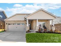 Charming single-Gathering home featuring a well-maintained lawn, stone facade, and attached two-car garage at 12636 Twilight Dr, Mint Hill, NC 28227