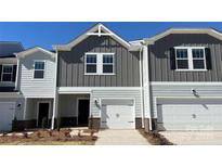 Charming townhome featuring a one-car garage, modern gray siding, and a well-manicured front yard at 1733 Braemar Village Dr, Monroe, NC 28110