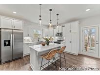 Bright white kitchen featuring a large island, stainless steel appliances, and stylish pendant lighting at 265 Red Fox Ln # 1P, China Grove, NC 28023