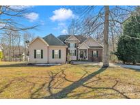 Charming two-story home with a brick and vinyl exterior, lush lawn, and an inviting entrance at 304 Keller St, China Grove, NC 28023