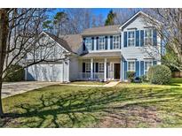 Charming two-story home featuring blue shutters, a front porch, and a well-maintained lawn on a sunny day at 3620 Cole Mill Rd, Charlotte, NC 28270