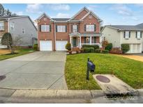 Charming brick two-story home with attached two-car garage and well-manicured front lawn at 6409 Chadwell Ct, Fort Mill, SC 29707