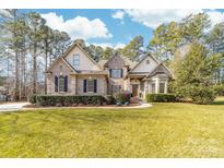 Beautiful two-story brick home with manicured lawn and mature landscaping at 7674 Bermuda Hills Ln, Denver, NC 28037