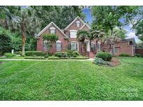 Beautiful two-story brick home with a manicured lawn and mature trees at 907 Thorn Ridge Ln, Lake Wylie, SC 29710