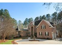 Stately brick home features a circular driveway, manicured landscaping, and timeless architectural details at 9135 Fair Oak Dr, Sherrills Ford, NC 28673