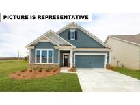 Charming home featuring a manicured lawn, a two-car garage, and a welcoming front porch at 103 Noah Ln, Troutman, NC 28166