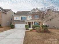 Charming two-story home features a two-car garage, landscaped yard, and neutral exterior finishes at 10335 Rutledge Ridge Nw Dr, Huntersville, NC 28078