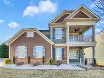 Charming two-story home with stone accents, a double porch, and manicured landscaping at 1062 Baldwin Dr, Lancaster, SC 29720