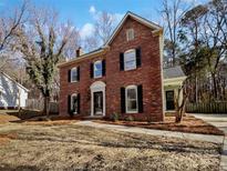 Charming two-story brick home featuring classic black shutters and a well-maintained front yard at 10906 Falls Branch Ln, Charlotte, NC 28214