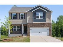 Two-story home boasts a stone facade, light brown siding, a two-car garage and manicured front lawn at 111 Rustling Waters Dr, Mooresville, NC 28117