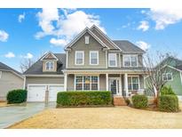 Charming two-story home boasts a manicured lawn, attached two-car garage, and inviting front porch at 1126 Snowbird Ln, Waxhaw, NC 28173