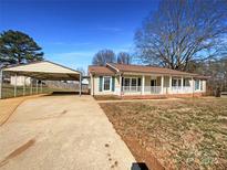 Charming single-story home featuring a covered carport, front porch and manicured lawn on a sunny day at 116 Hedgestone Dr, Gastonia, NC 28056