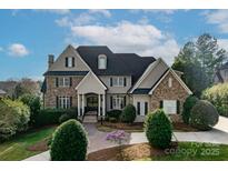 Charming two-story home featuring a blend of stone and stucco exterior, well-manicured landscaping, and a welcoming entrance at 1506 Venetian Way Dr, Waxhaw, NC 28173