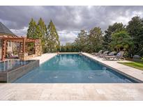 Backyard pool area with lounge chairs and pergola for relaxing and enjoying the outdoors at 1506 Venetian Way Dr, Waxhaw, NC 28173