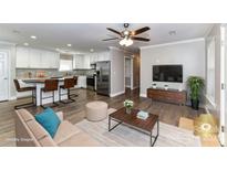 Bright open-concept living room flows into kitchen with island, stainless appliances, and modern finishes at 1511 Liberty Ave, Albemarle, NC 28001