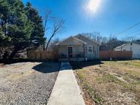Charming single-story home with a cozy front porch, wood fence, and walkway leading to the entrance at 205 W Parkwood St, Stanley, NC 28164